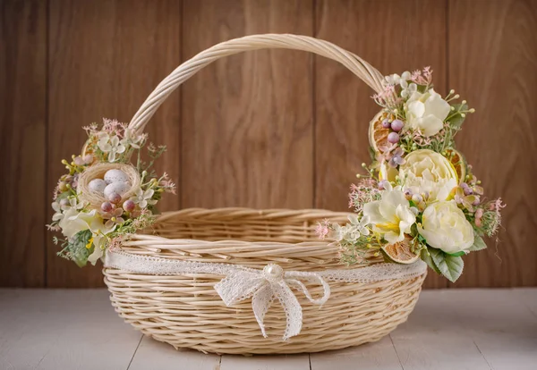 Feestelijke mand, versierd met bloemen op houten achtergrond. — Stockfoto