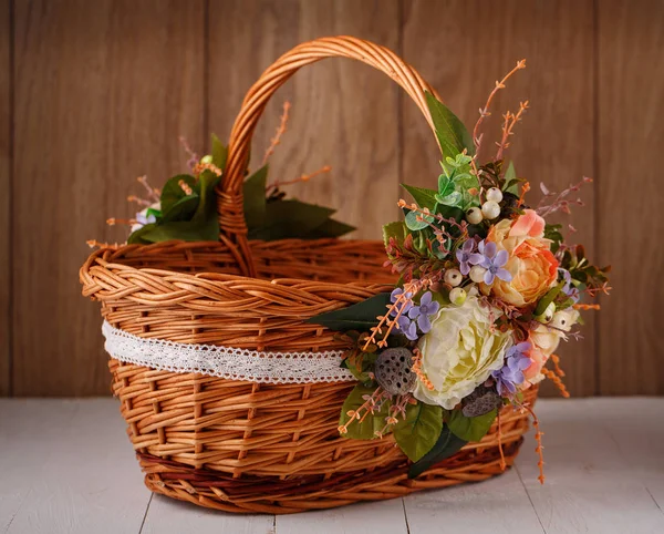 Designer basket is decorated with flowers. Wicker basket for celebrating Easter and other holidays. — Stock Photo, Image