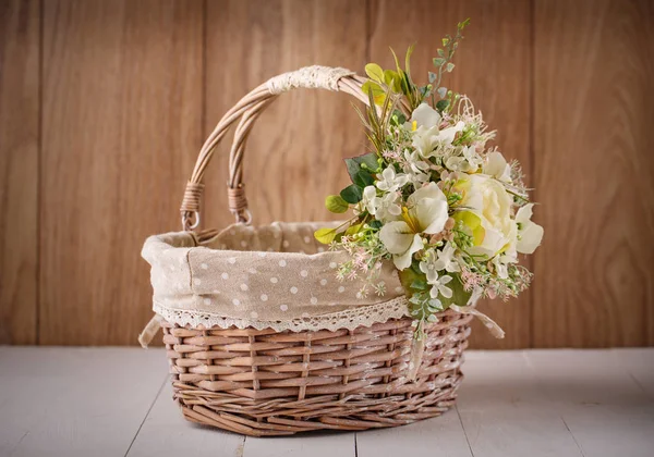 Святковий кошик, прикрашений квітами на дерев'яному фоні . — стокове фото