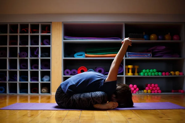 Une femme, un entraîneur de yoga, fait des affaires incroyables et s'étire — Photo