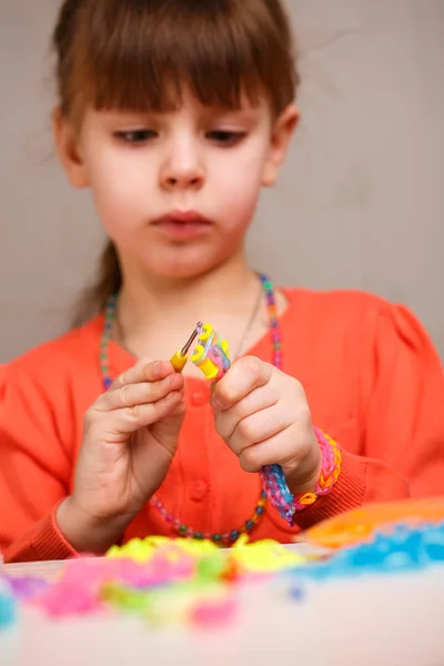 Хобі милі дівчата плетуть яскраві кольорові гумові браслети — стокове фото