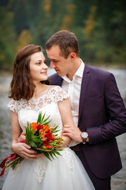 Yeni evliler birbirlerinin gözleri, nehir kıyısında ayakta bakmak