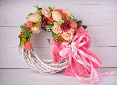 Dekoratif dokuma çelenk çiçek ve bıldırcın yumurtası ile süslüdür.