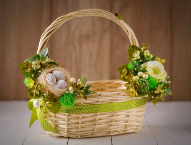 Ahşap bir arka planda Paskalyayı kutlamak için çiçekli sepet.