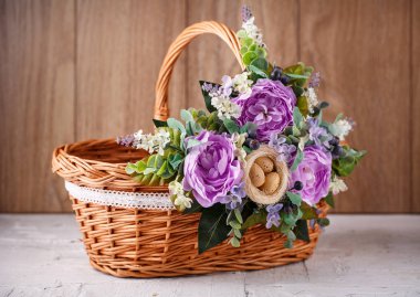 Ahşap bir arka planda Paskalyayı kutlamak için çiçekli sepet.