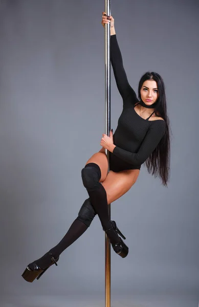 Frau, die Pole Dance aufführt. Aufnahme mit grauem Hintergrund. — Stockfoto