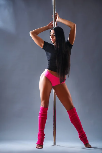 Giovane donna atletica che fa un allenamento di fitness con i tubi. Poledance sport show — Foto Stock