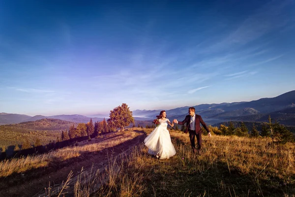 Homme et femme viennent de se marier dans les montagnes au coucher du soleil . — Photo