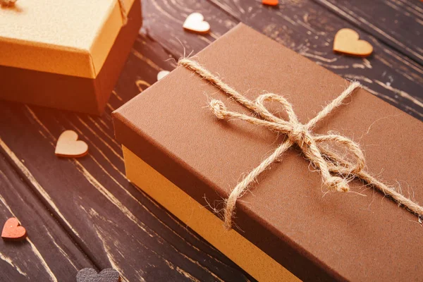 Cajas de regalo marrón sobre fondo de madera con un lazo de una simple cuerda — Foto de Stock