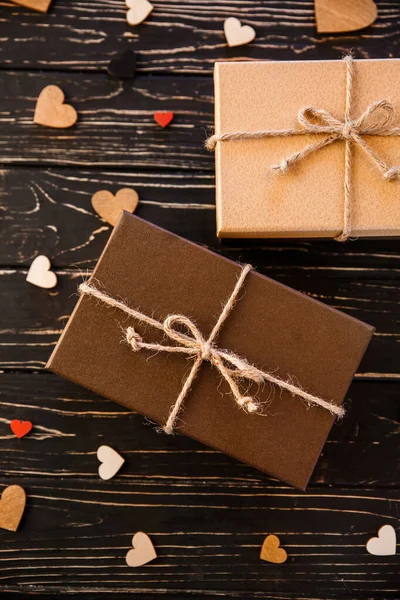 Two brown gift boxes on a wooden background with a bow of a simp — Stock Photo, Image