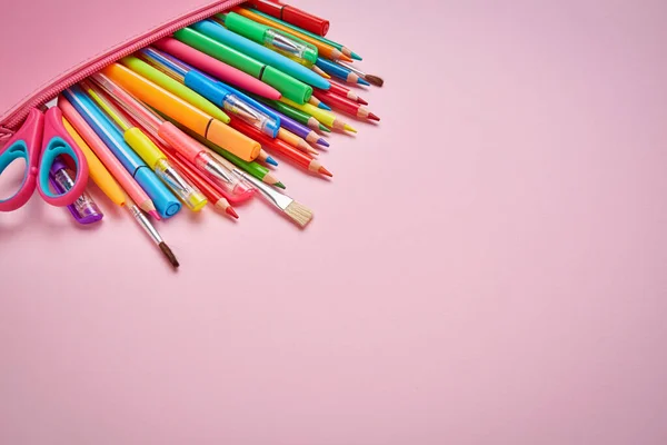 Papelería brillante en el estuche de lápiz está acostado en un fondo rosa —  Fotos de Stock