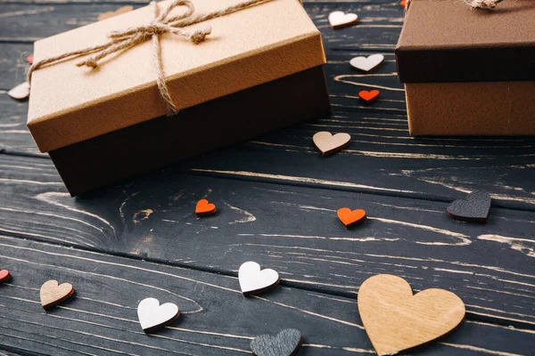 Corazones de madera decorativos y una caja de regalo — Foto de Stock