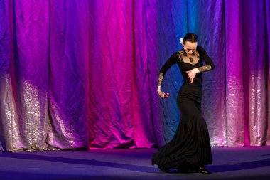 Siyah elbiseli duygusal aktris dans ediyor ve tiyatro sahnesinde rol alıyor..