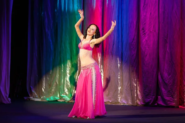 Hermosa mujer bailando danza del vientre en un traje rosa . — Foto de Stock