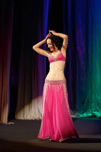 Mujer bailando en un traje oriental rosa bailando danza del vientre en el escenario del concierto — Foto de Stock