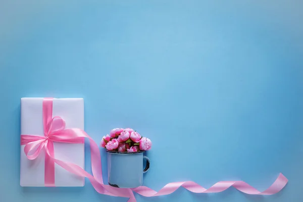 Κουτί δώρου τυλιγμένο σε λευκό χαρτί με ροζ κορδέλα — Φωτογραφία Αρχείου