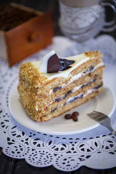 Cake with honey and prunes on a white plate — Stock Photo, Image