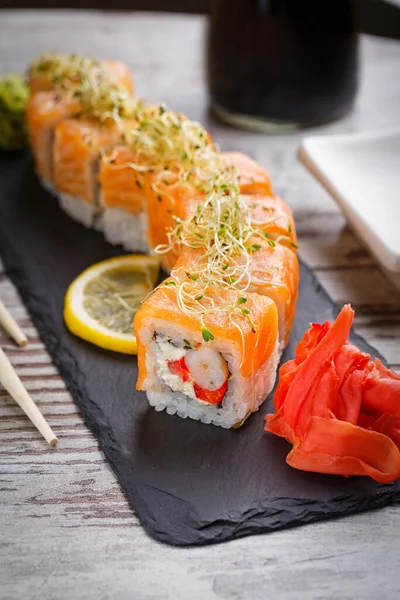 Традиционные японские суши с лосося, имбиря и isabi на черном камне текстурной доски. Суши в ресторане . — стоковое фото