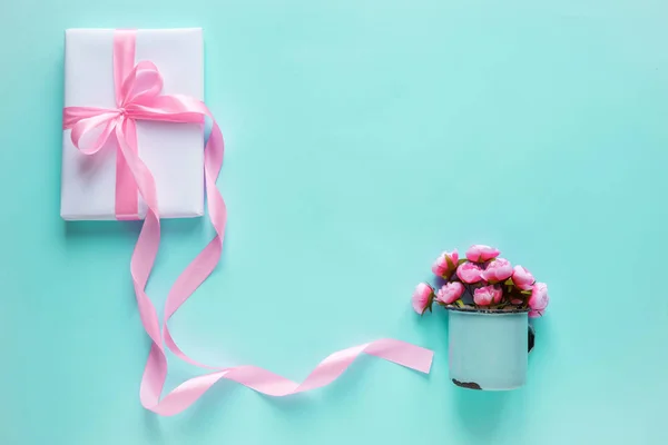 Geschenkdoos verpakt in wit papier met roze lint — Stockfoto