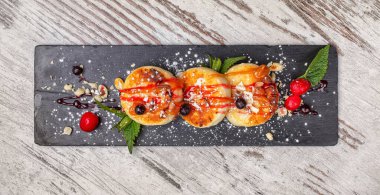 Mutfak tahtasında reçel olan tatlı çörekler. Basit bir ahşap arka plan. Lokantada lezzetli bir tatlı..