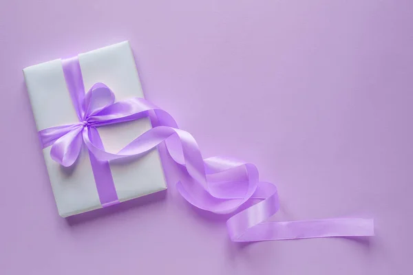 Nastro viola su una confezione regalo bianca su sfondo viola. Concetto della vacanza. Posto per testo — Foto Stock