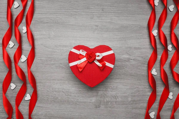 Confezione regalo rossa sotto forma di cuore. Nastri a forma di cuore a spirale e decorativo . — Foto Stock