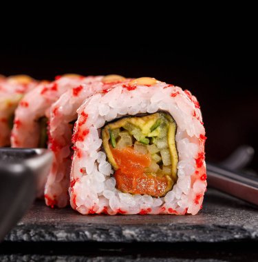 Çubuklu suşi ve soya sosu. Japon yemeği. Sebzeli, balıklı ve havyarlı suşi. Kapat..