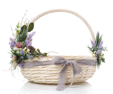 Çiçek ve kurdeleli doğal hasır sepet. Sepet sapında güzel bir çiçek dekoru var. Beyaz bir arkaplanda izole edilmiş.