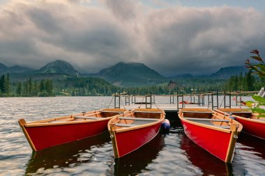 Dağ gölü içinde Yüksek Tatras Ulusal Park. Strbske Pleso, Slovakya. Güneşin ışınları dağ gölde tekne ile yatak.
