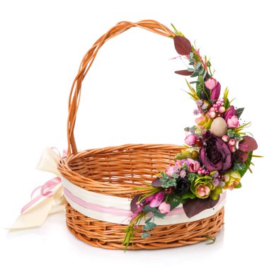 Mor çiçekleri, yeşilliği ve kurdeleleri olan güzel bir çiçek kompozisyonu beyaz arka plandaki hasır sepetin sapında asılı..