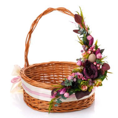 Çiçekler, paskalya yumurtaları ve geniş kurdelelerle süslenmiş klasik tarzda el yapımı Paskalya sepeti. Beyaz arkaplanda izole.