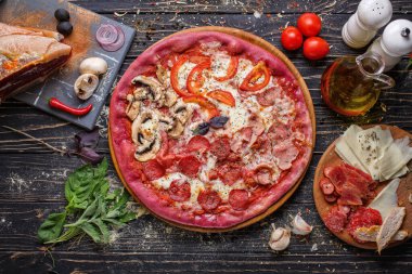 Mantar, domates, peynir, soğan, yağ, biber, tuz, fesleğen, jambon, sarımsak ve ahşap zemin üzerinde lezzetli İtalyan pizzası pişirmek için gıda malzemeleri ve baharatlar. Üst görünüm
