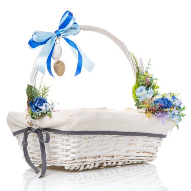 Beyaz arka planda mavi çiçekli, kurdeleli ve dekoratif yumurtalı beyaz Paskalya sepeti.