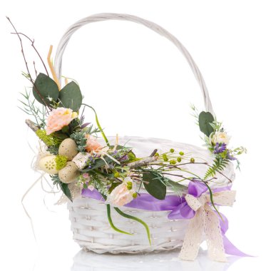 Çiçeklerle, yeşilliklerle ve sepetin etrafında mor kurdeleyle süslenmiş ahşap dallarla süslü sepet. beyaz arkaplan