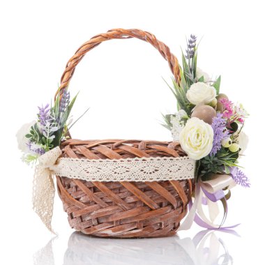 Hassas renkli pastel renkli çiçeklerle süslenmiş kahverengi sepet ve beyaz arka planda kurdeleler. Köy tarzında yapılmış.