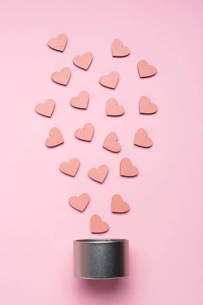 Серебряная металлическая подарочная коробка и декоративные деревянные сердца на розовом фоне . — стоковое фото
