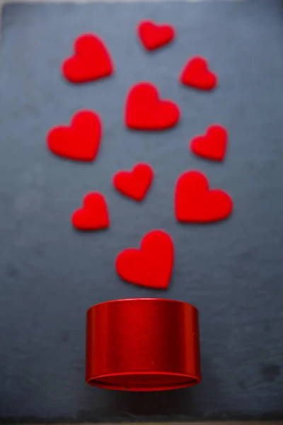 Regalo romántico, concepto de amor. Corazones de fieltro rojo y caja de regalo redonda roja sobre fondo oscuro —  Fotos de Stock