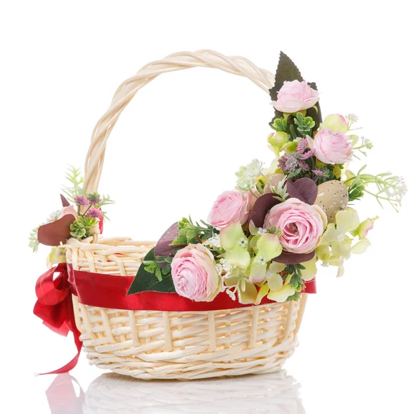 Цветочные украшения розовых роз на плетеной корзине с красной лентой. Изолированный на белом фоне — стоковое фото