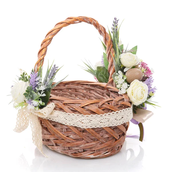 Beautiful large wicker basket with delicate flowers, lavender, greens and net. Decorated in a rustic style on white background — Stock Photo, Image