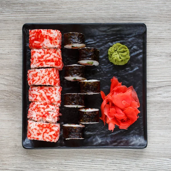 日本料理店 寿司の2種類のセット 生姜とわさびと正方形の黒いプレート上の寿司 トップ表示 — ストック写真