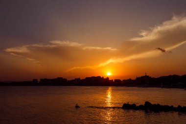 Şehrin üzerinde gün batımı. Şehrin deniz kenarındaki silueti. Dramatik bir gökyüzü. Yaz Sveti Vlas, Bulgaristan, Sunny Beach