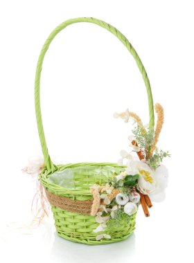 Beyaz arkaplanda çiçeklerle süslenmiş hasır sepet.