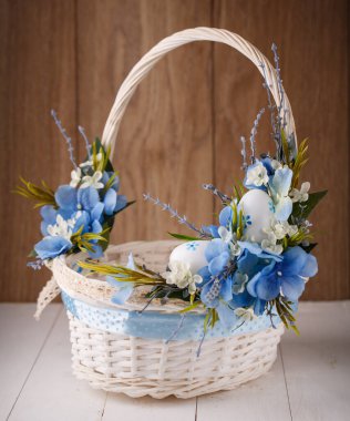 Ahşap bir arka planda Paskalyayı kutlamak için çiçekli sepet.