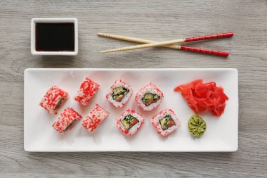 Çubuklu suşi, zencefil, soya sosu ve wasabi. Japon yemeği. Sebzeli, balıklı ve havyarlı suşi. Üst görünüm