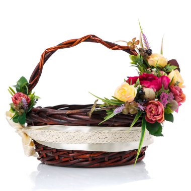 Orijinal saplı koyu kahverengi hasır sepet ve beyaz arka planda çiçek süslemesi. Sarı ve pembe çiçeklerin dekoru, yeşil. geniş kurdele ve dantel. Yan görünüm.