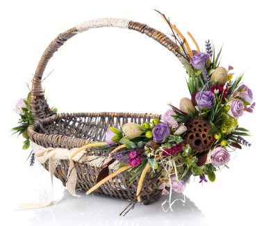 Orijinal saplı kahverengi hasır sepet. Çiçekli, yumurtalı ve kurdeleli. Paskalya kutlaması için yapıldı. Beyaz bir arkaplanda izole edilmiş