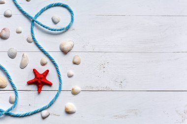 Yaz arkaplanı kırmızı deniz yıldızı ve mavi ahşap arka planda deniz kabukları. Fotokopi alanı olan bir yaz tatili. Üst görünüm.