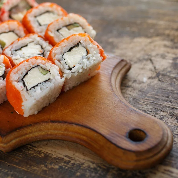 Sushi Rolka Lososem Avokádem Sýrem Dřevěné Desce Rustikálním Pozadí — Stock fotografie