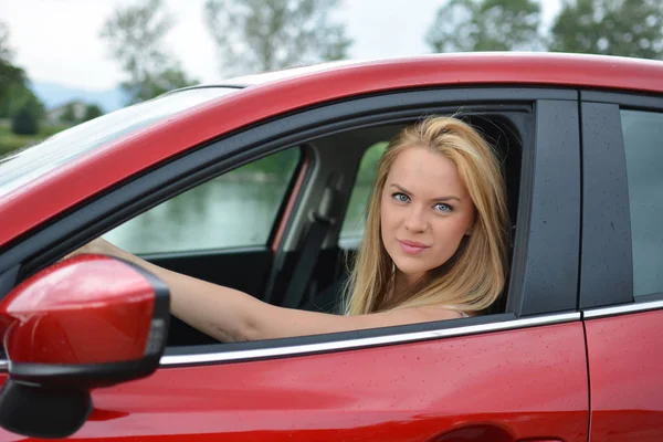 Jeune fille conduite voiture rouge — Photo