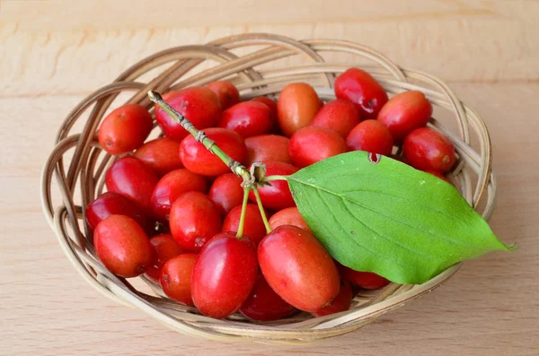 Wicker basket full of Cornelian cherries — Stock Photo, Image